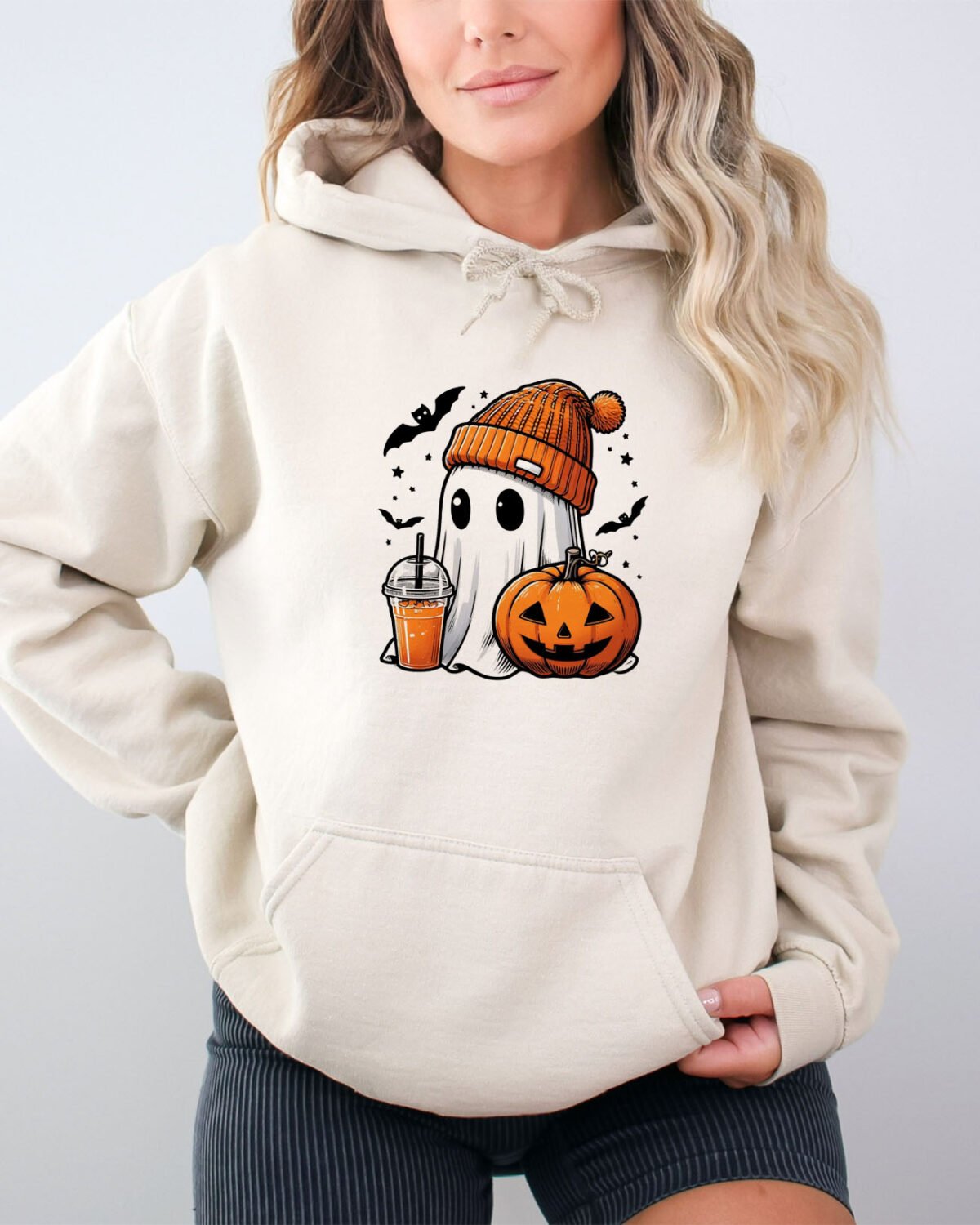 Woman wearing a cute ghost hoodie in sand beige color