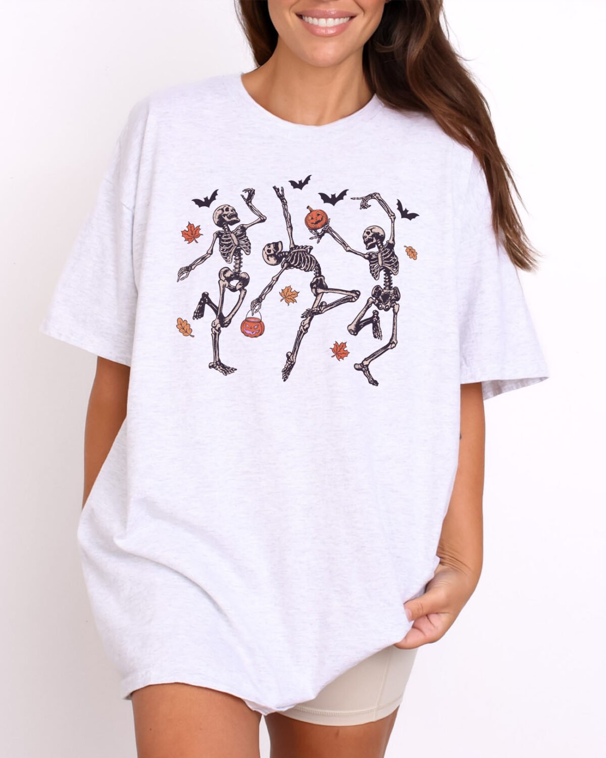 Woman wearing a Dancing Skeletons Shirt in ash grey color with a funny skeleton halloween graphic