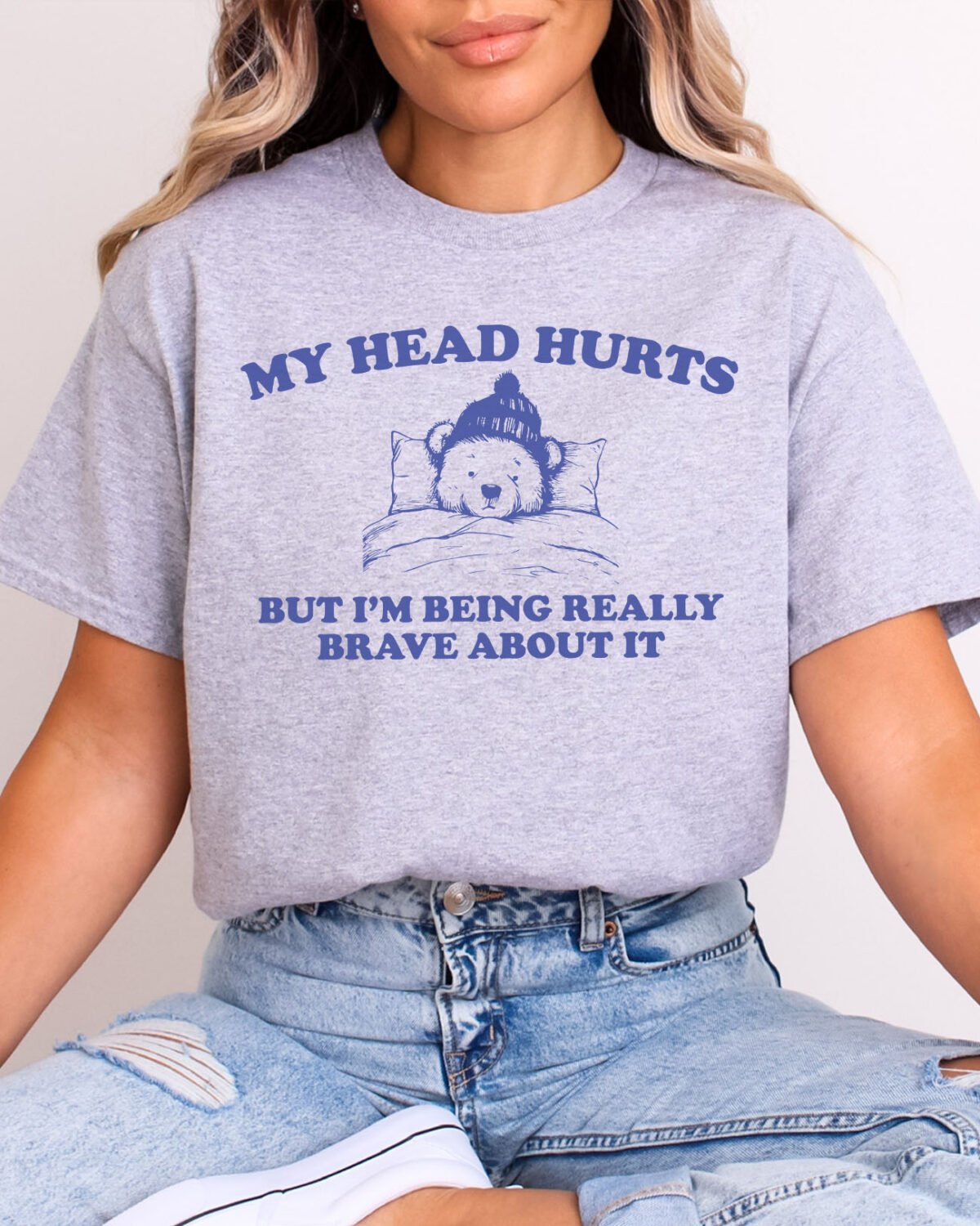 Woman wearing a sport grey My Head Hurts But I'm Being Really Brave About It T-Shirt with a cute retro bear graphic