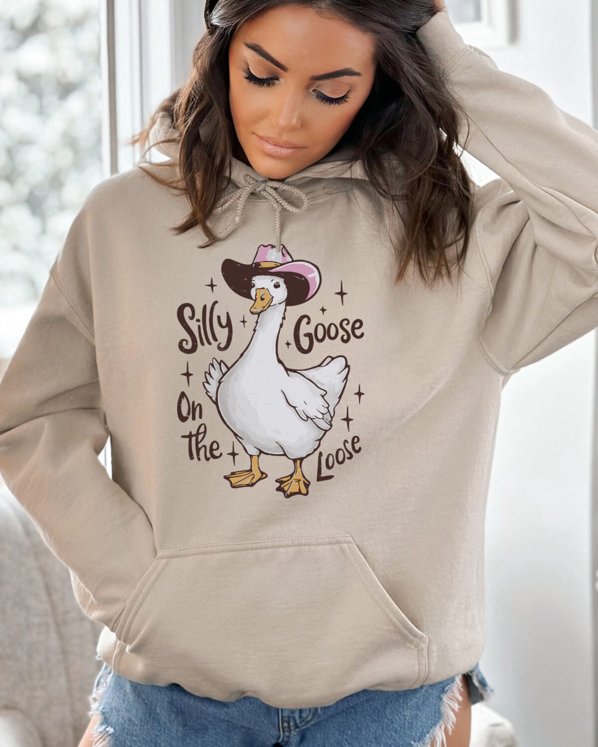 Woman wearing a silly goose on the loose hoodie in sand beige color