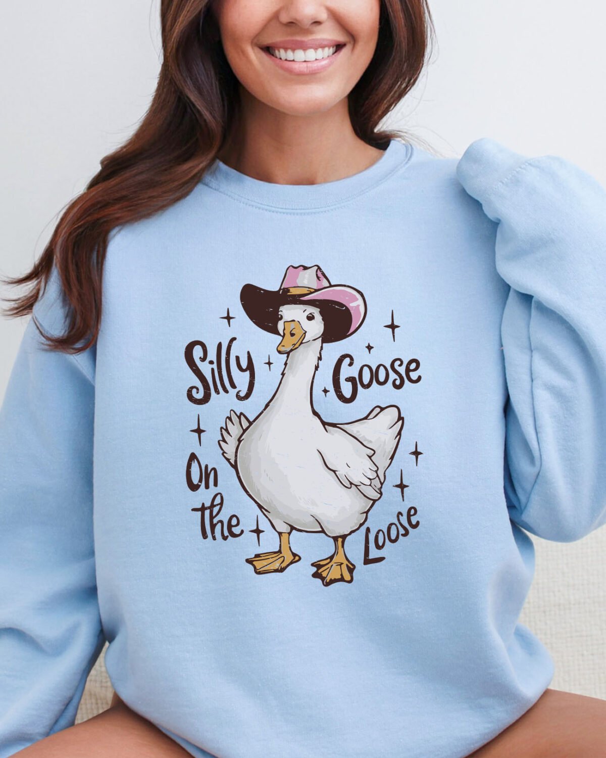 Woman wearing a silly goose on the loose sweatshirt in light blue color