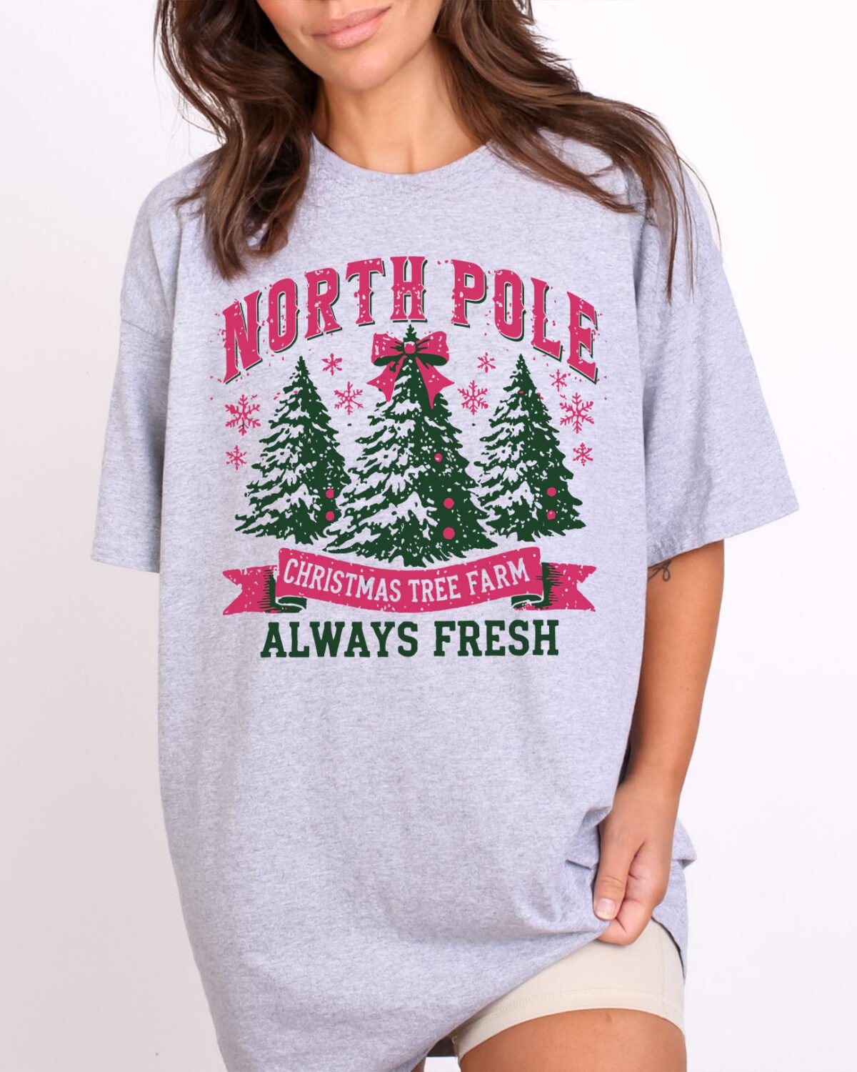 Woman wearing a "North Pole Christmas Tree Farm Shirt" graphic tee in sport grey color