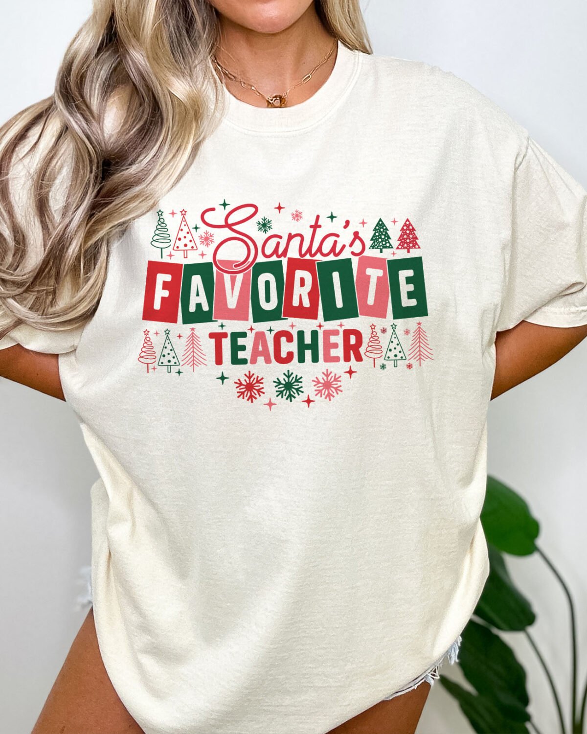 Woman wearing a funny Santa's Favorite Teacher shirt in natural beige color